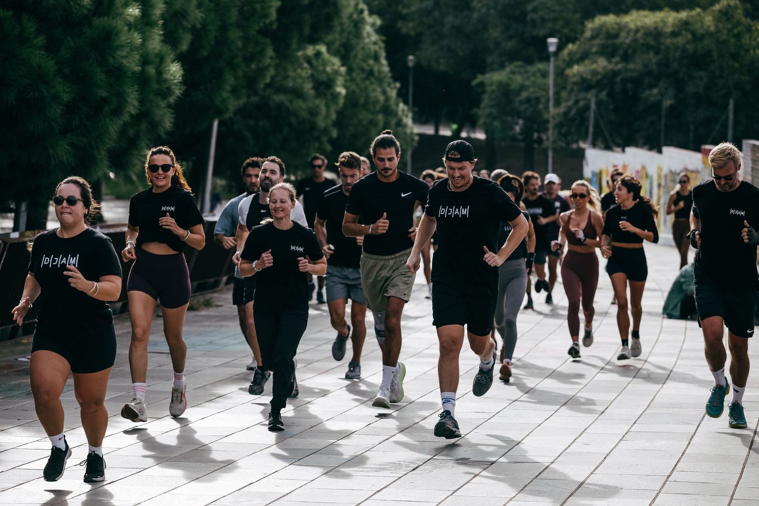 Large group running in formation wearing black athletic gear.