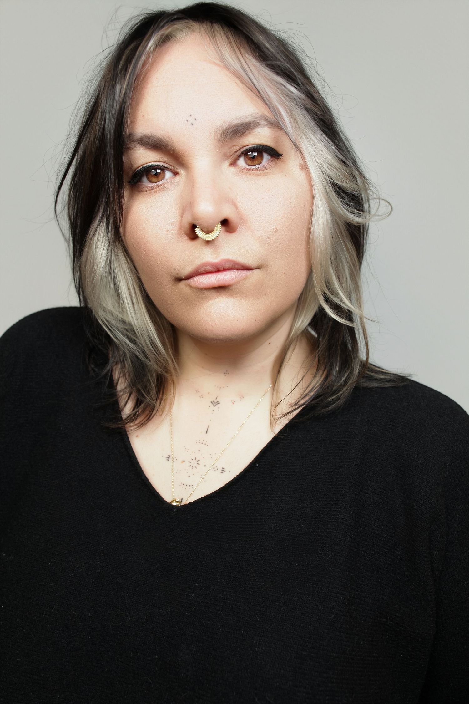 Artistic portrait series featuring dramatic angles and lighting against neutral backdrop.
