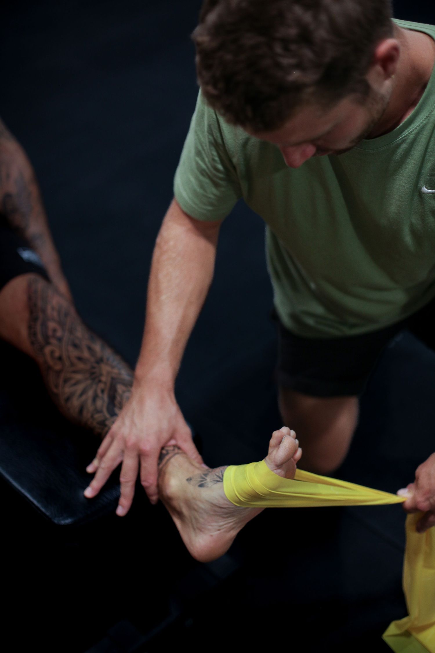 Person demonstrating therapeutic taping technique on foot.