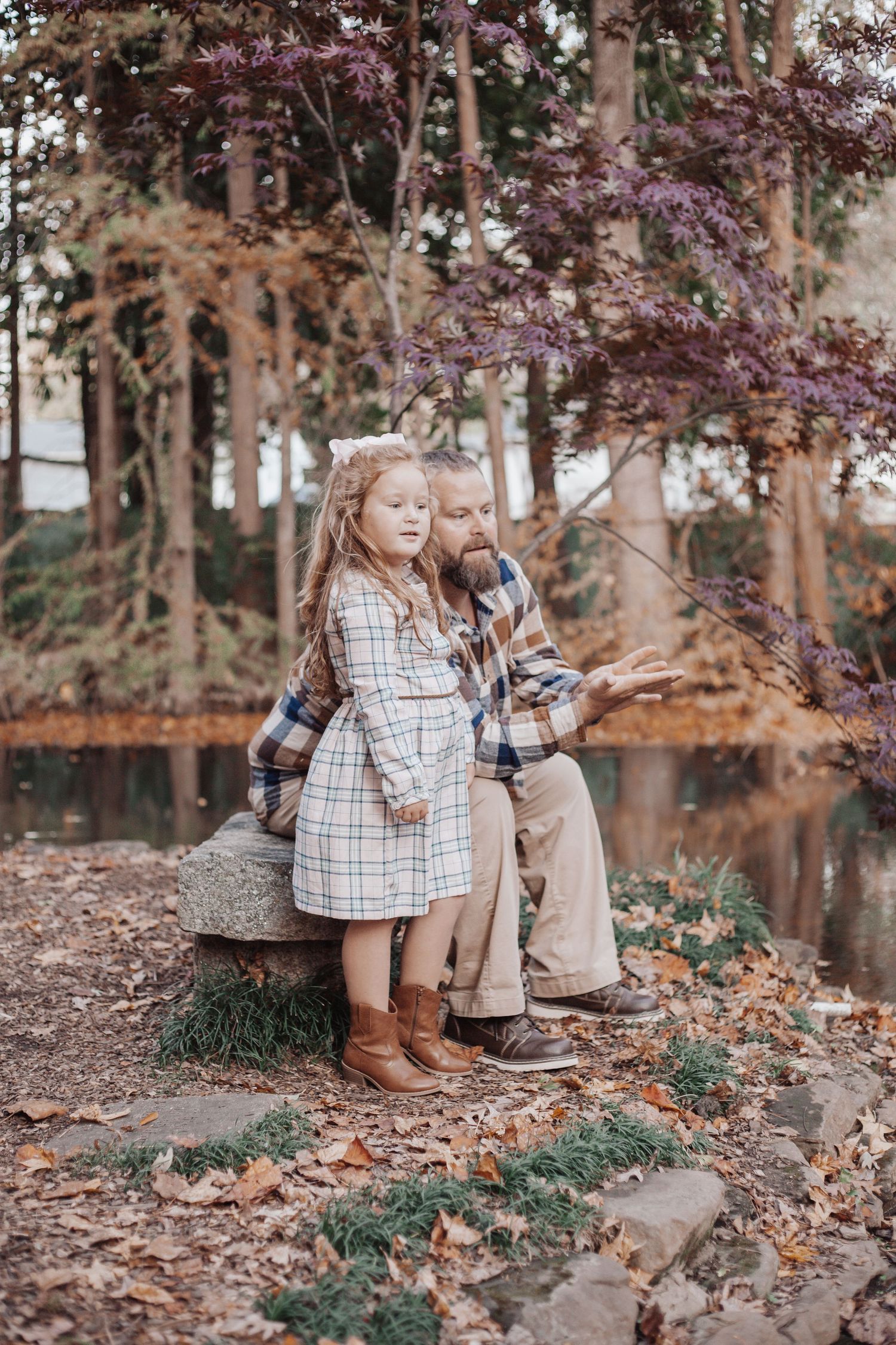 father daughter in upstate south carolina for family photo shoot with pond behind them and looking out over the water