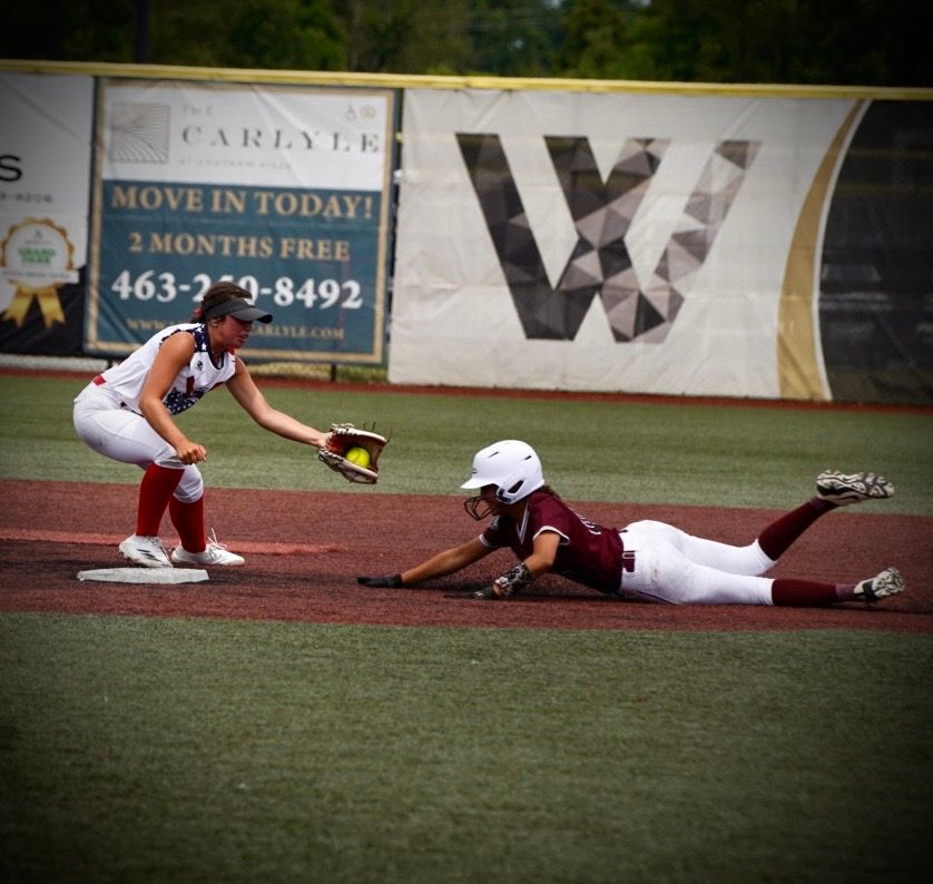 Baseball player sliding into base during intense gameplay action on field.