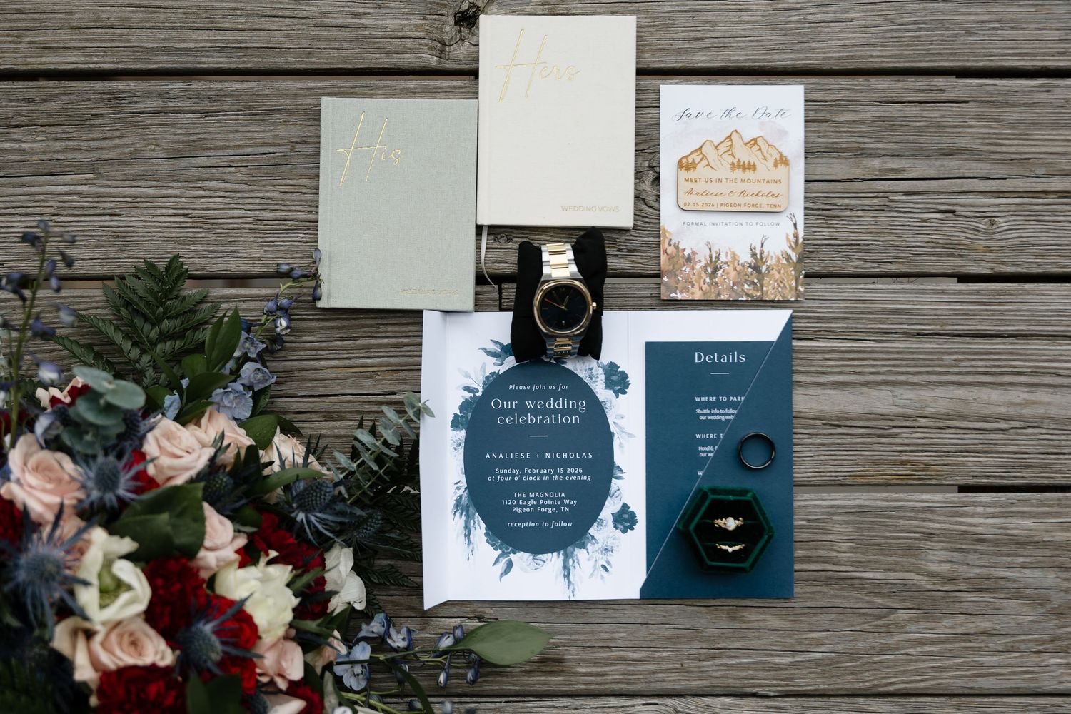 Wedding flat lay featuring invitation suite, floral bouquet, gold watch, and rings on rustic wood backdrop.