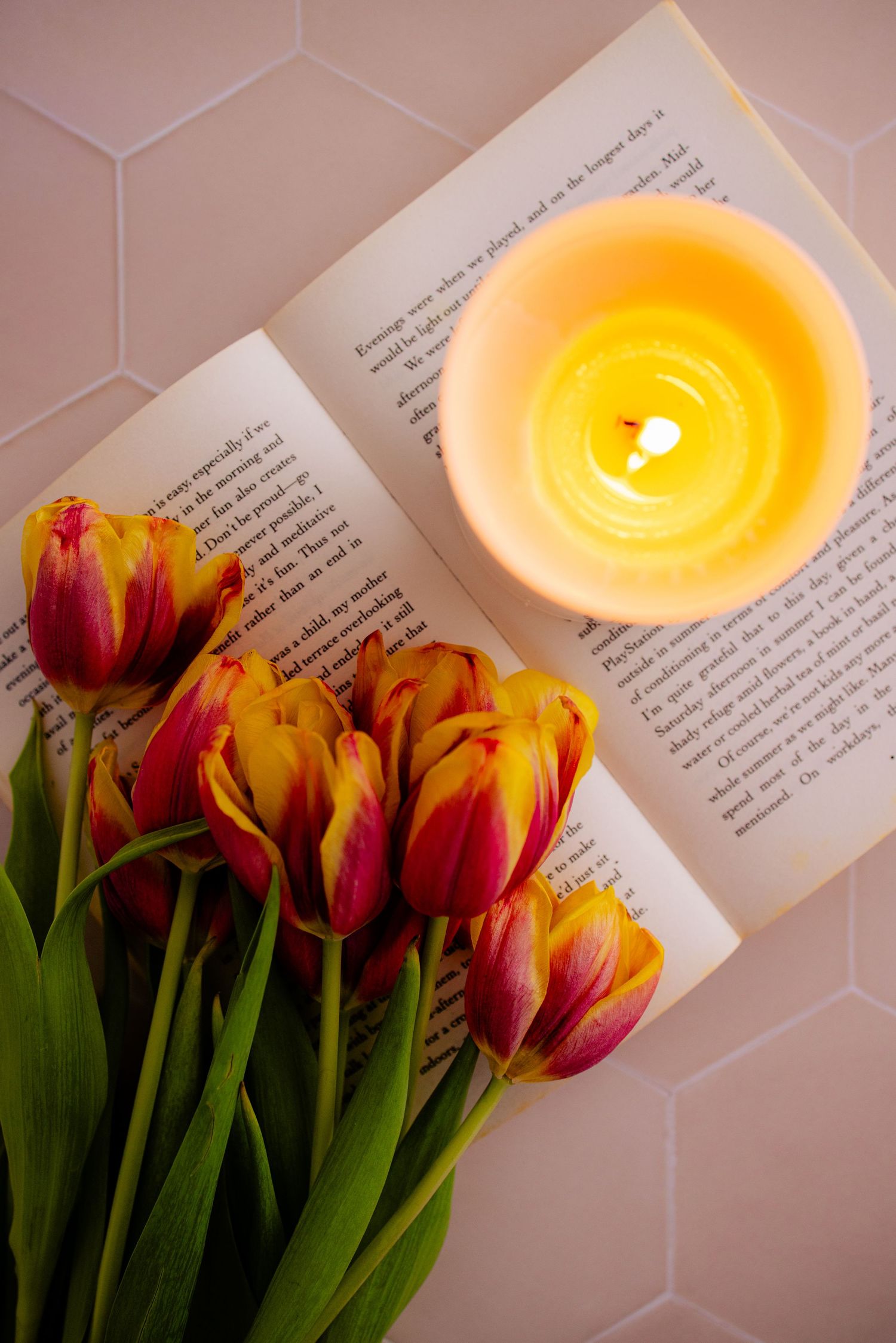 Seasonal content photography of a soy wax candle, tulips and book by an East Kent content photographer.