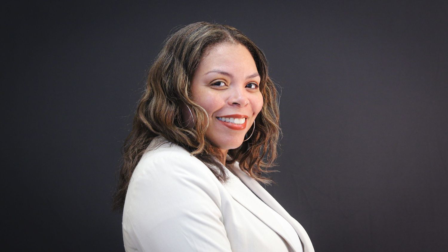 Professional headshot series showing warm smiles against dark background in various poses.