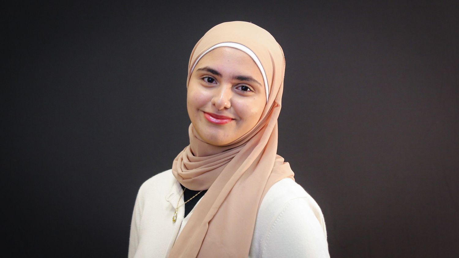 Five headshots of a person wearing a peach-colored hijab against a dark background, shown in different poses and expressions.