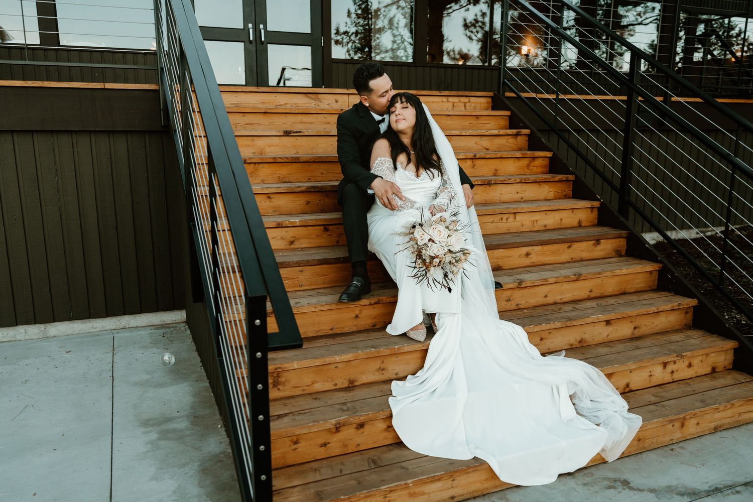 Bride and groom posing on wooden outdoor staircase at River Run Lodge, Eagle Crest