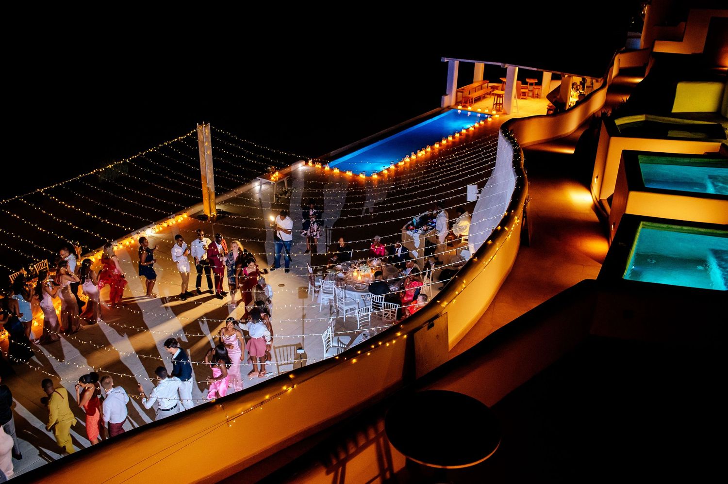 Nighttime outdoor wedding reception with string lights creating warm ambiance.