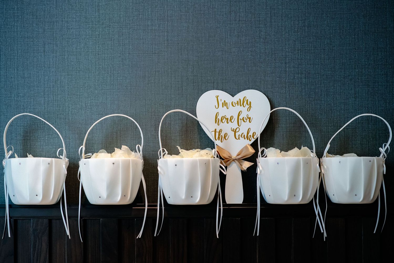 A row of white wedding headbands with delicate floral details displayed against a dark blue background.