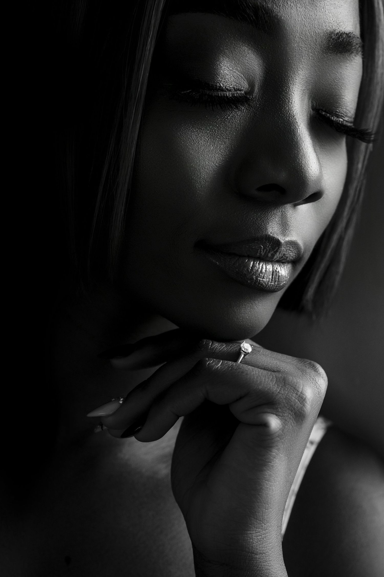 Dramatic black and white close-up portrait with moody lighting and shadows.