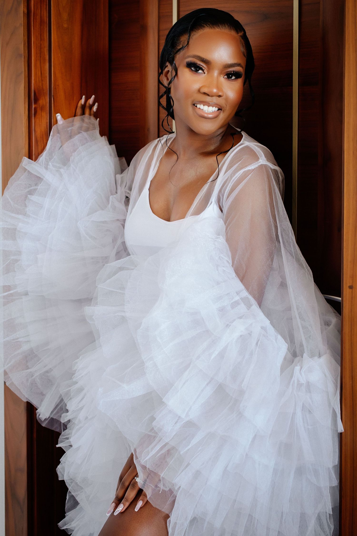 A stunning bridal portrait featuring a white tulle robe and natural makeup look.