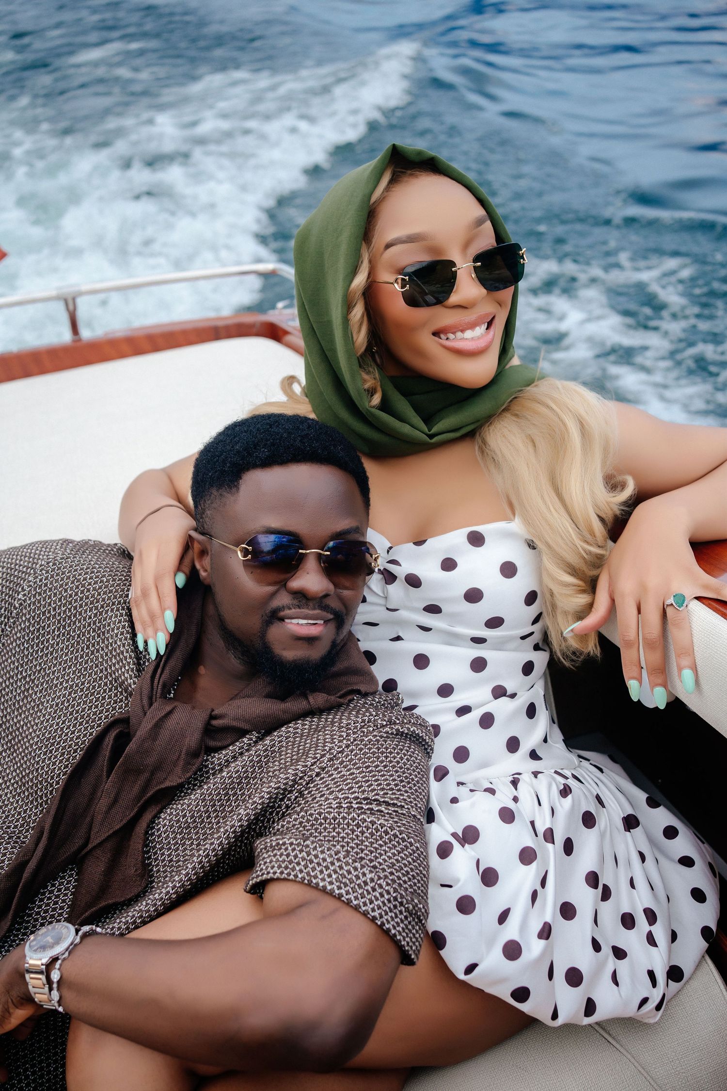 Romantic couple enjoying a boat ride together on sparkling blue waters.