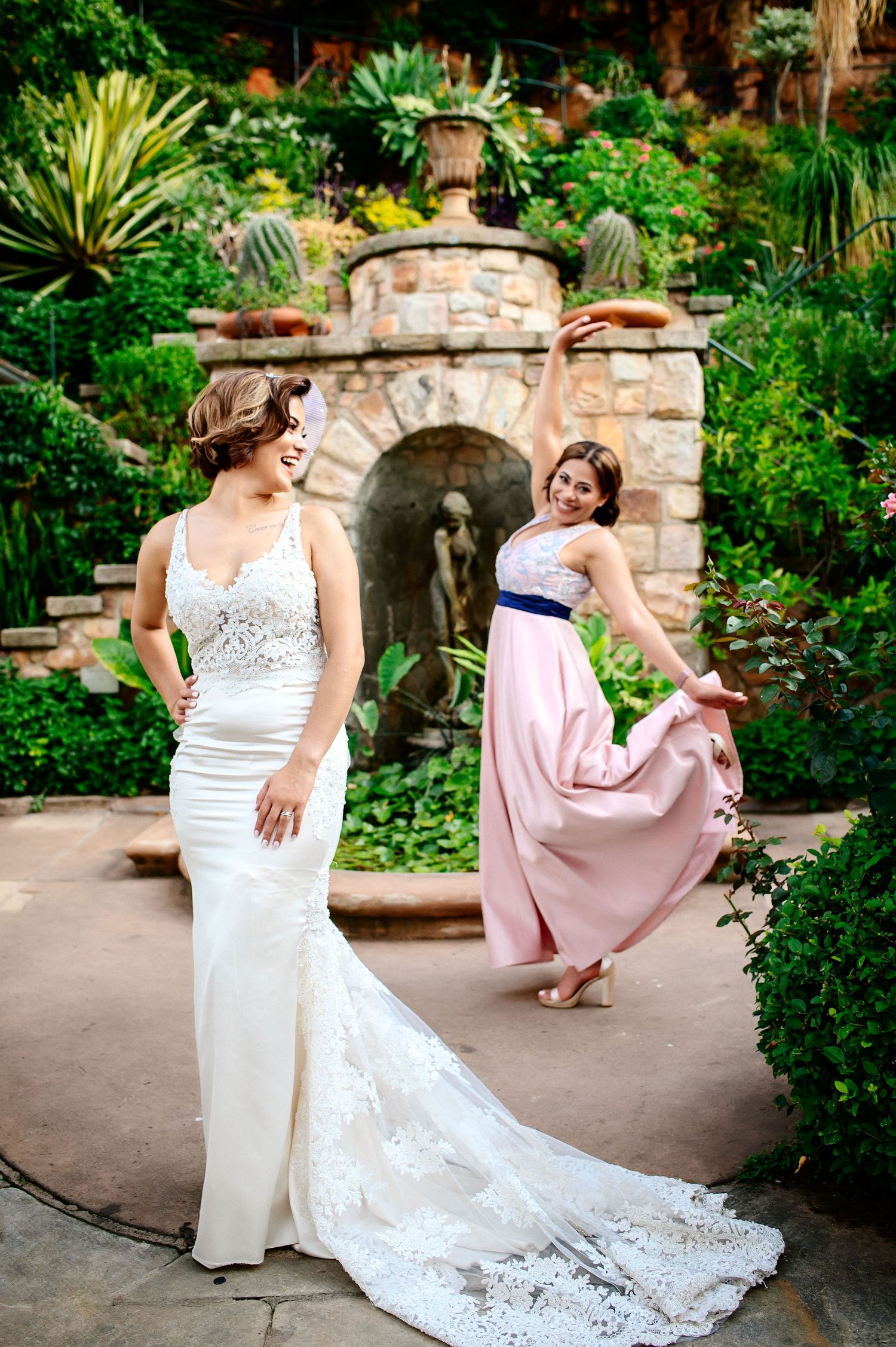Wedding photo session in lush garden setting with elegant bridal gowns.