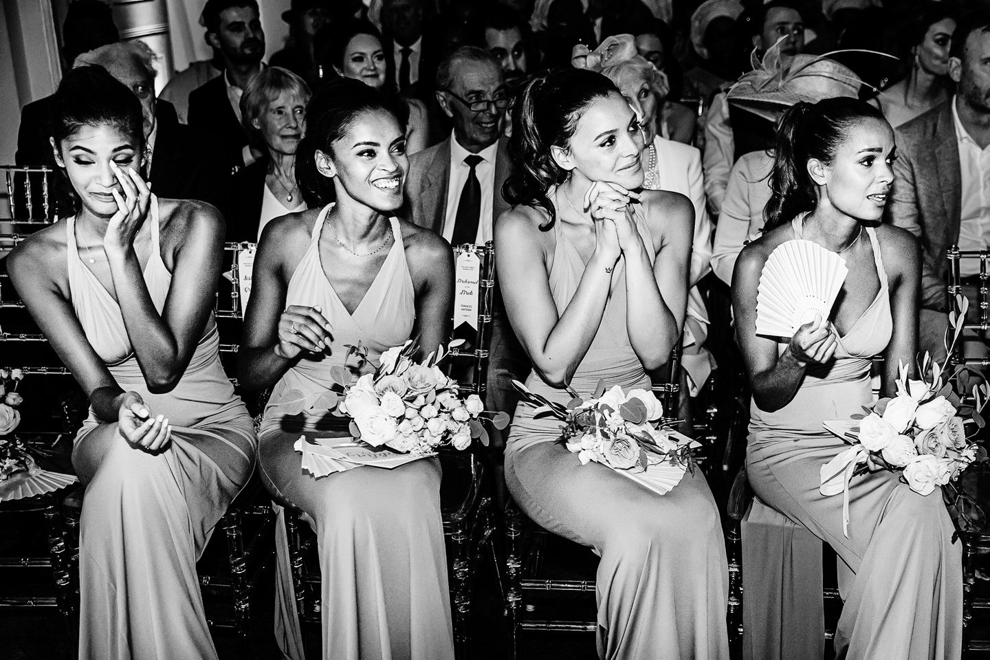 A series of black and white photos showing bridesmaids in matching dresses reacting emotionally during a wedding moment.