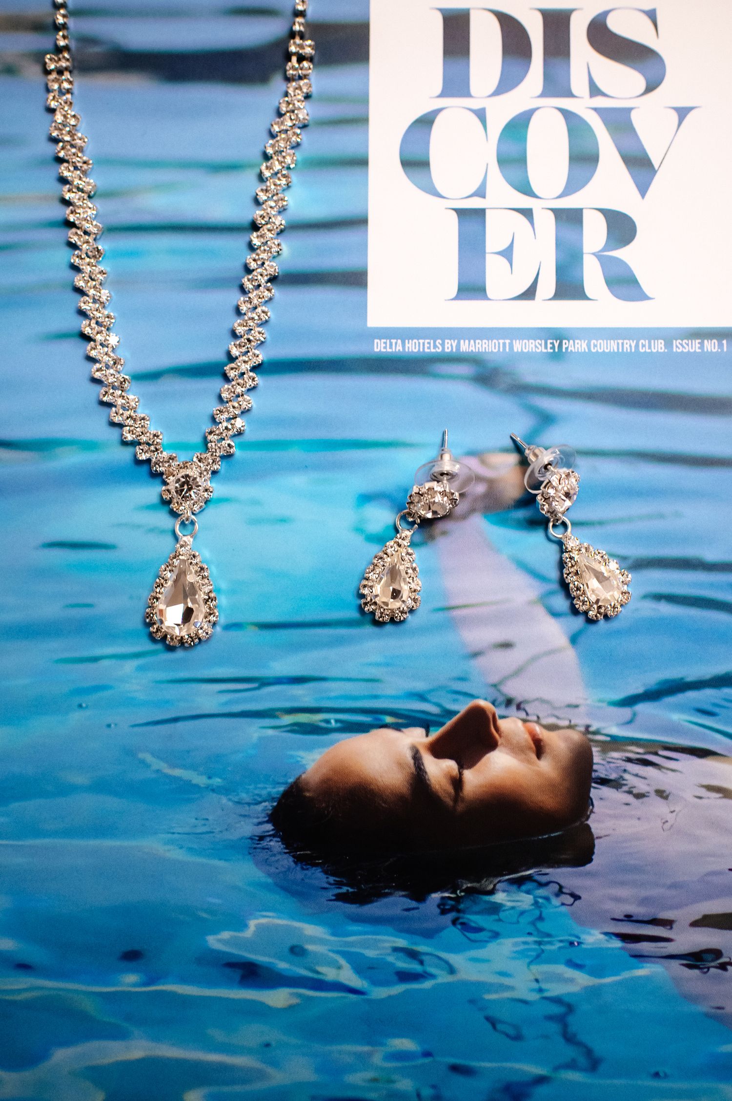 Fashion magazine cover featuring jewelry and water elements in blue tones.