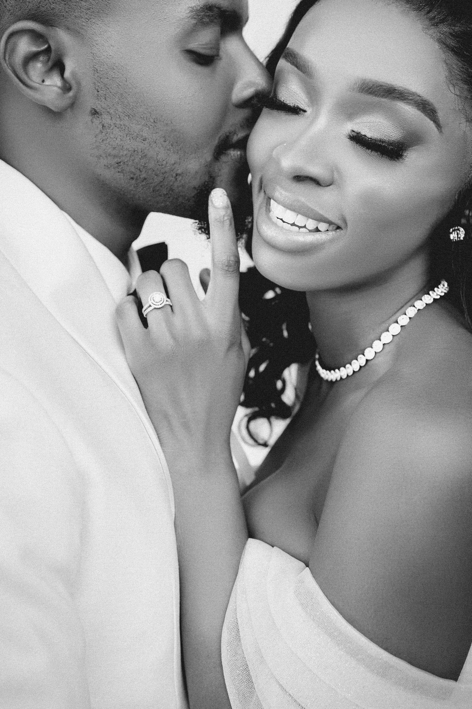 Romantic black and white portrait capturing intimate wedding moment with jewelry details.