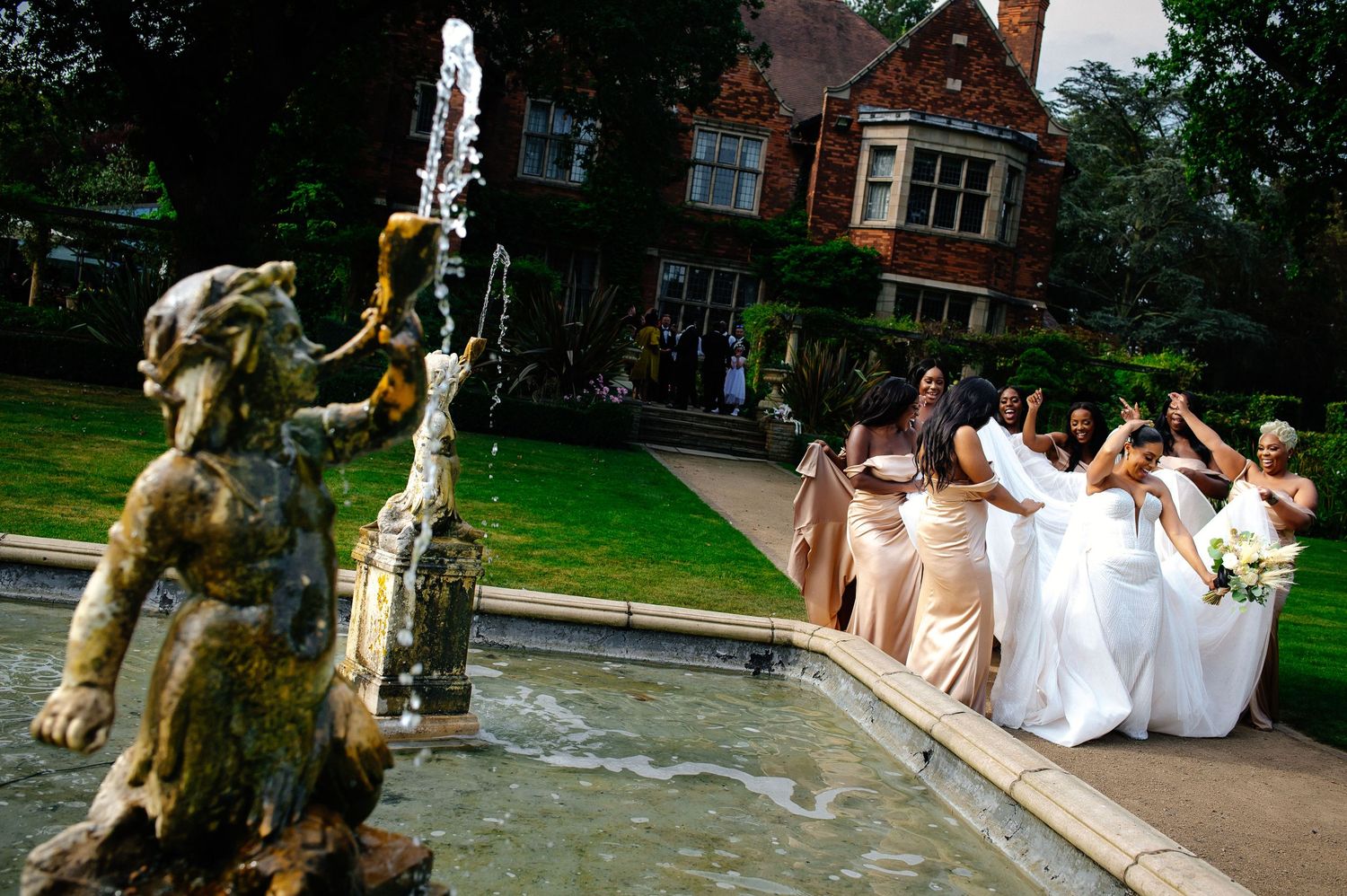 Wedding party celebrates joyfully on outdoor patio with raised glasses and laughter.