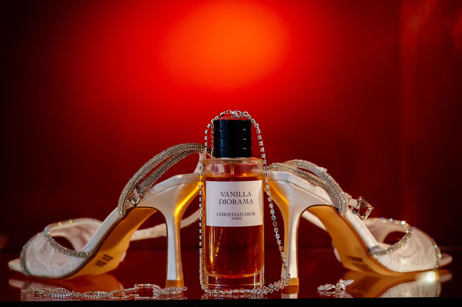 Luxury perfume bottle photographed against a dramatic red background.