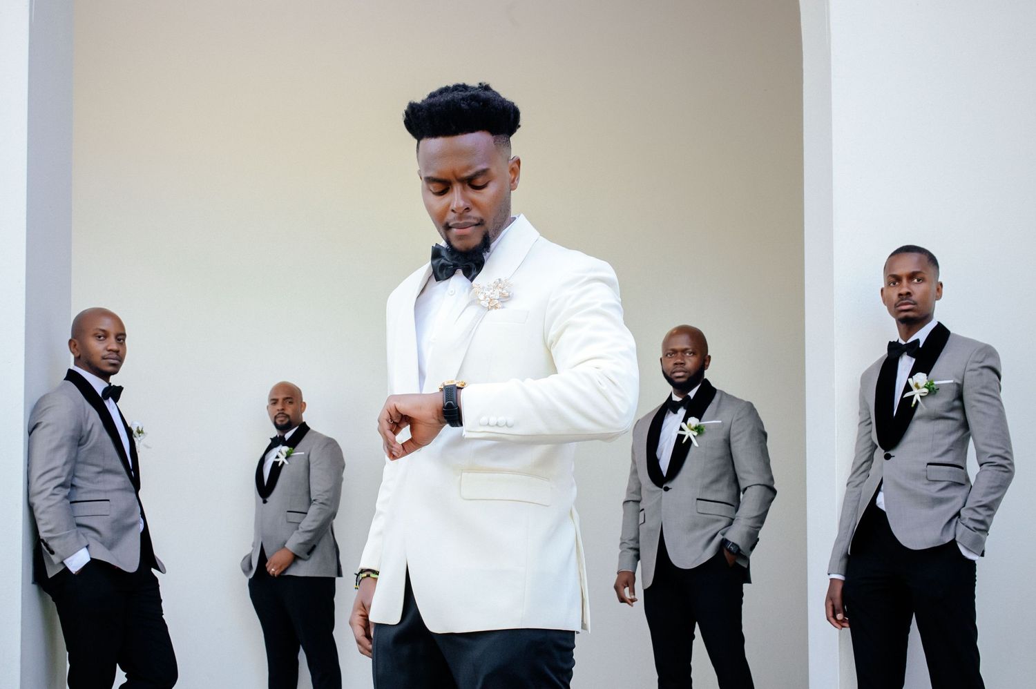 Groomsmen in formal attire pose for stylish group photos.