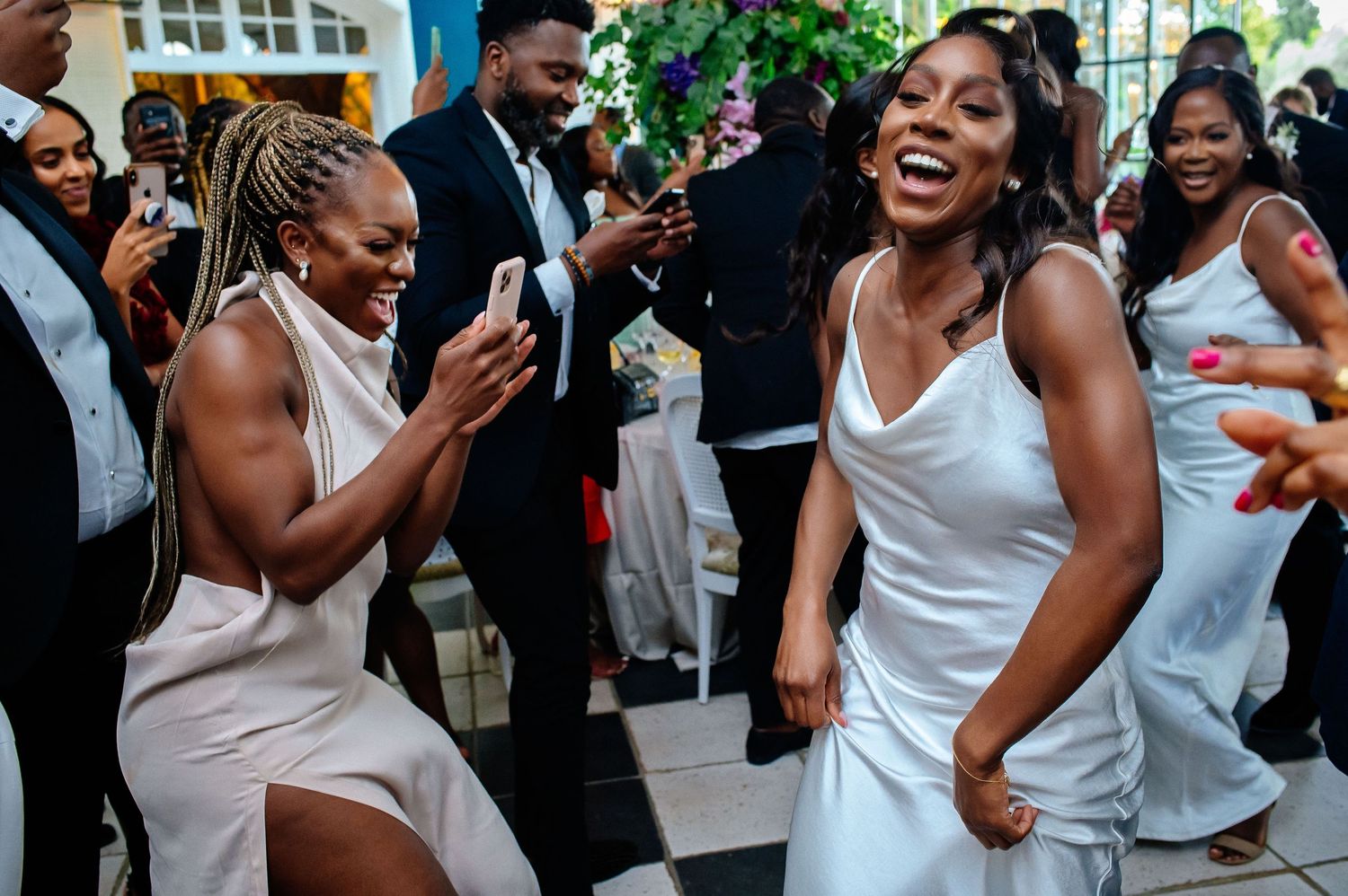 Energetic dance party celebration with guests in white attire.