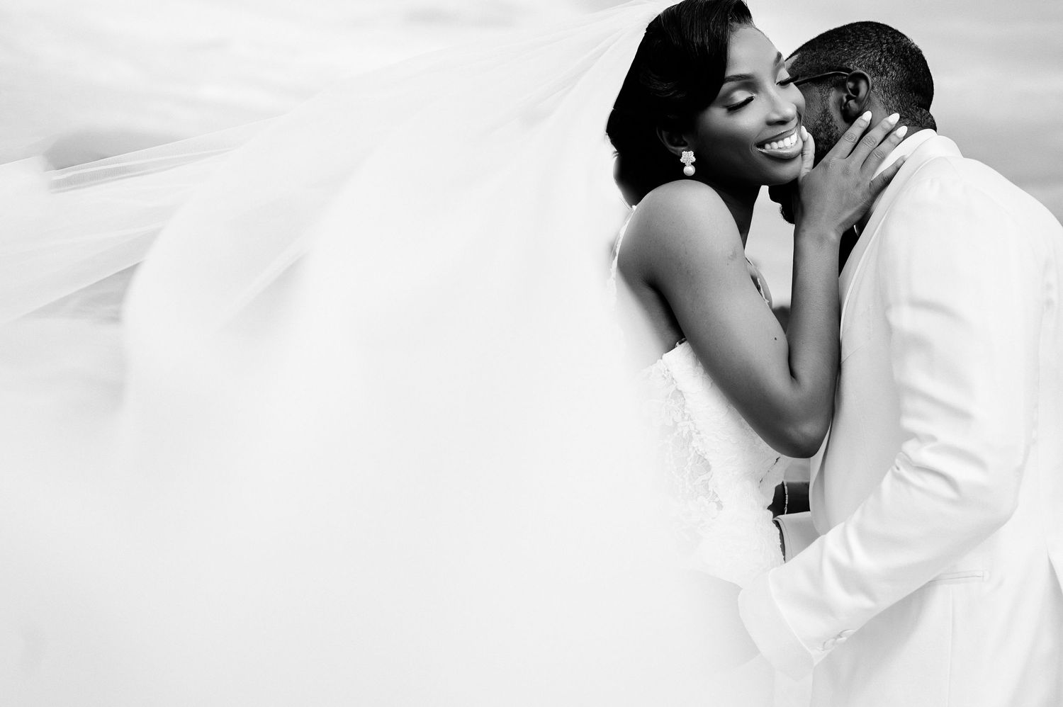 An intimate black and white wedding portrait capturing a tender moment between newlyweds.