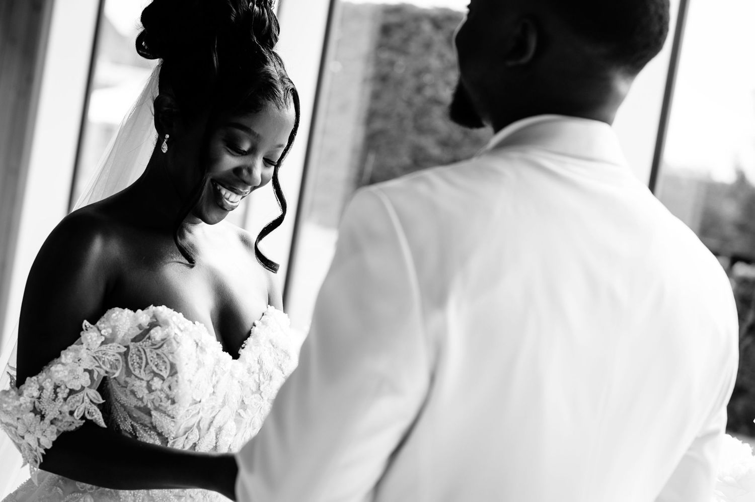 Black and white intimate wedding moment with bride in lace gown.
