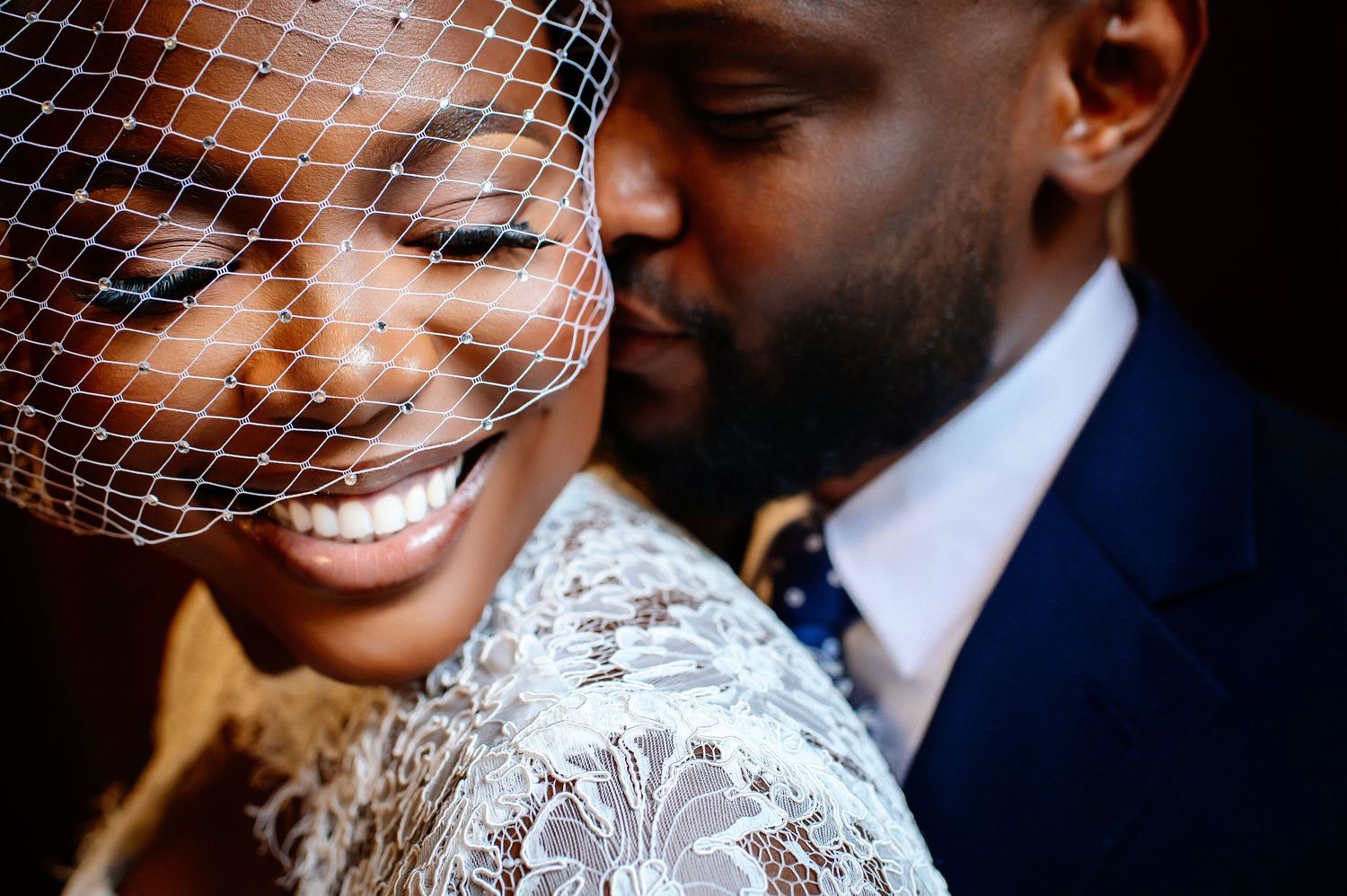 Romantic wedding portrait capturing a tender moment between newlyweds against a blurred background.