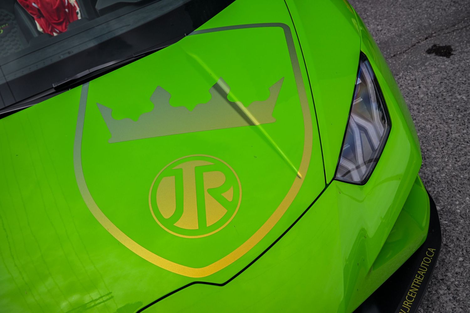 Close-up view of a lime green Lamborghini hood featuring a prominent gold crown logo decal graphic.