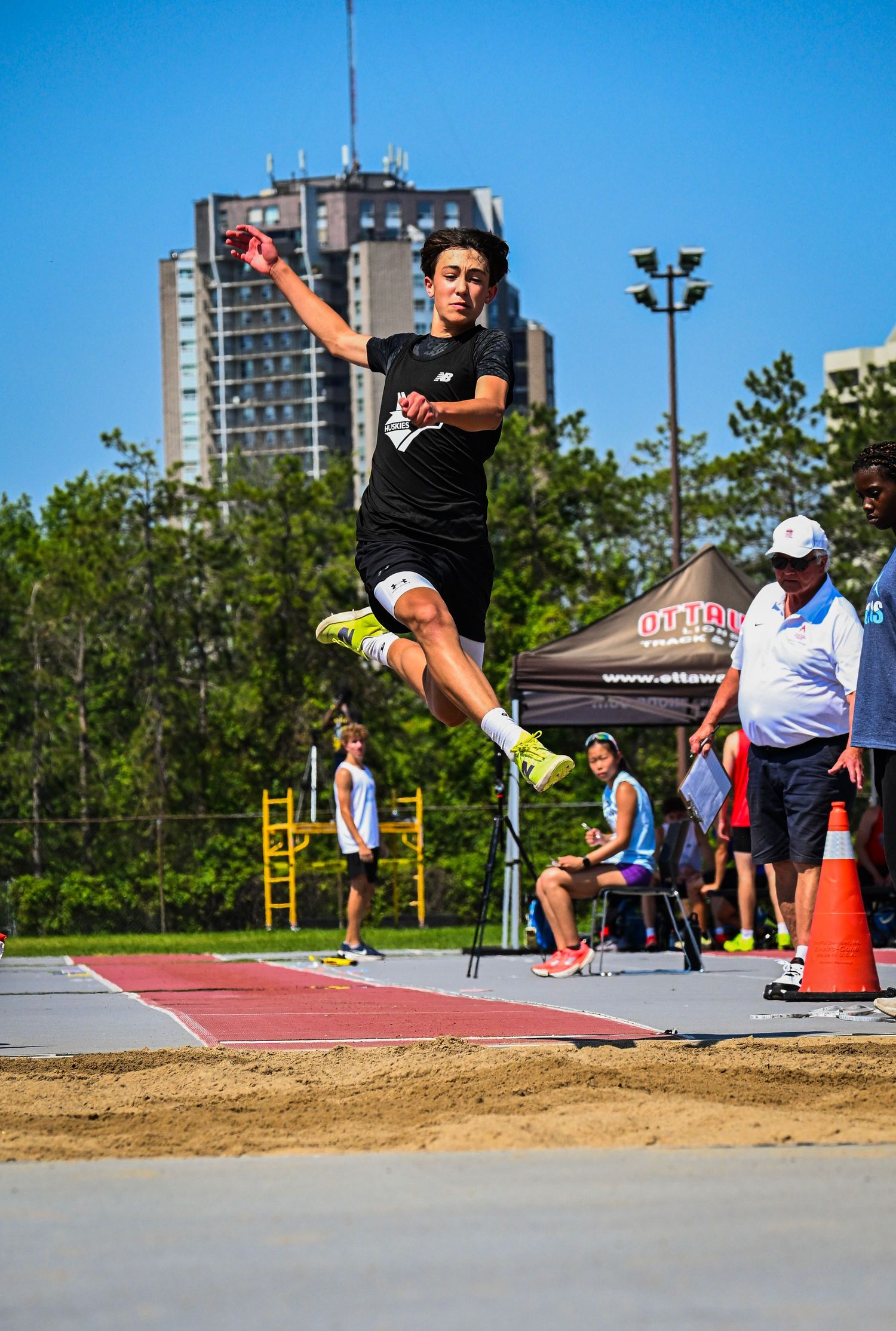 A track and field athlete suspended mid-air during a long jump competition.