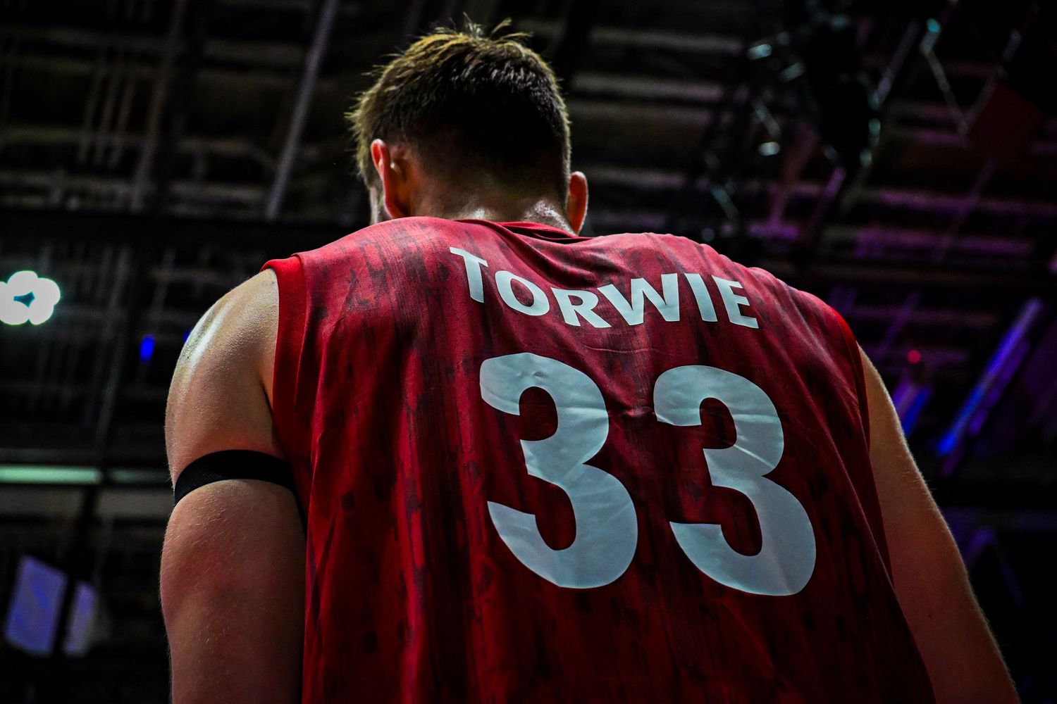 Back view of a volleyball player wearing a red jersey with the name Torwie and number 33.