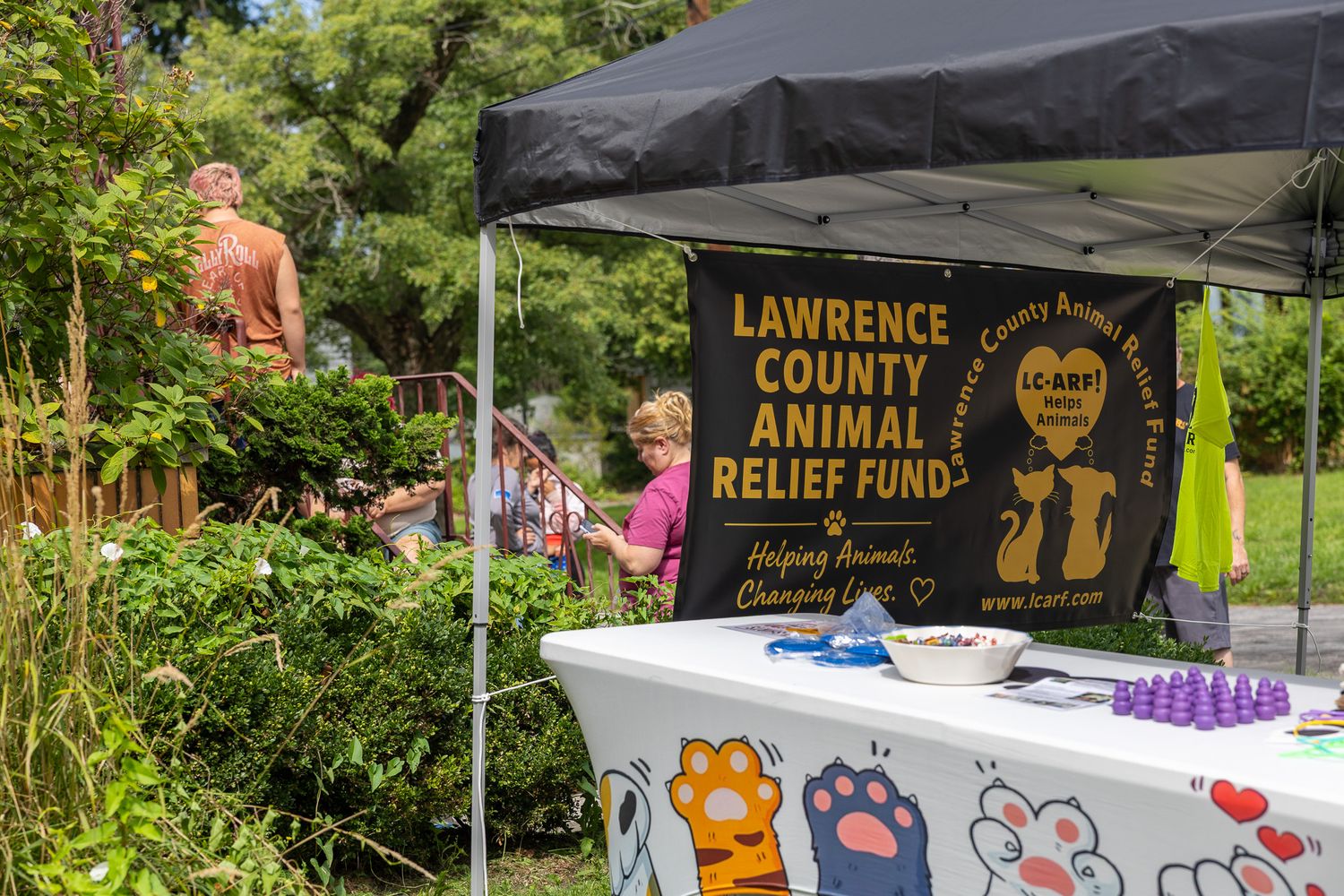 Lawrence County Animal Relief Fund outdoor booth with colorful paw print tablecloth at a community event.