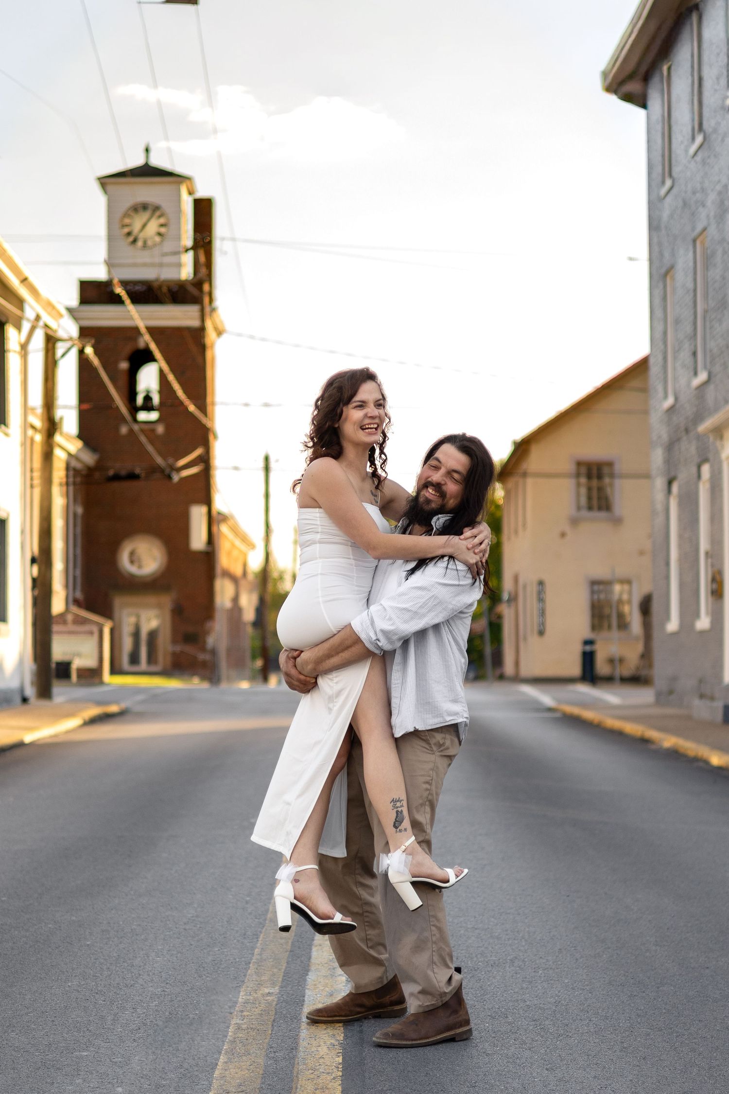 Joyful couple embracing in the middle of a historic town street.