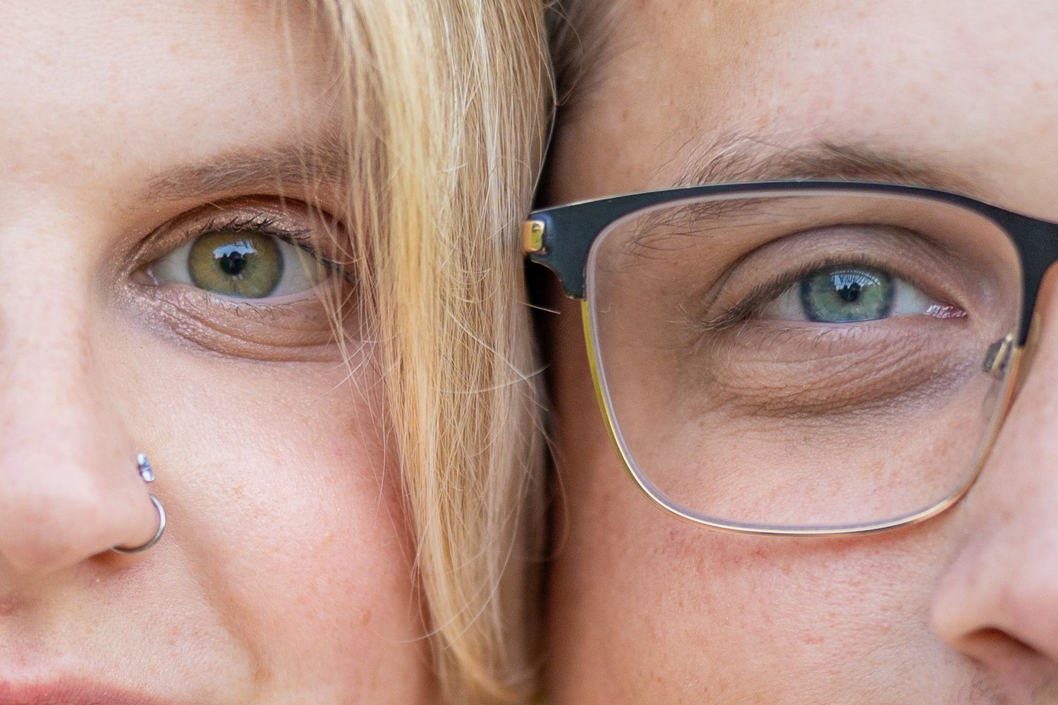 Close-up portrait of a couple's eyes, woman with nose ring and man wearing glasses.