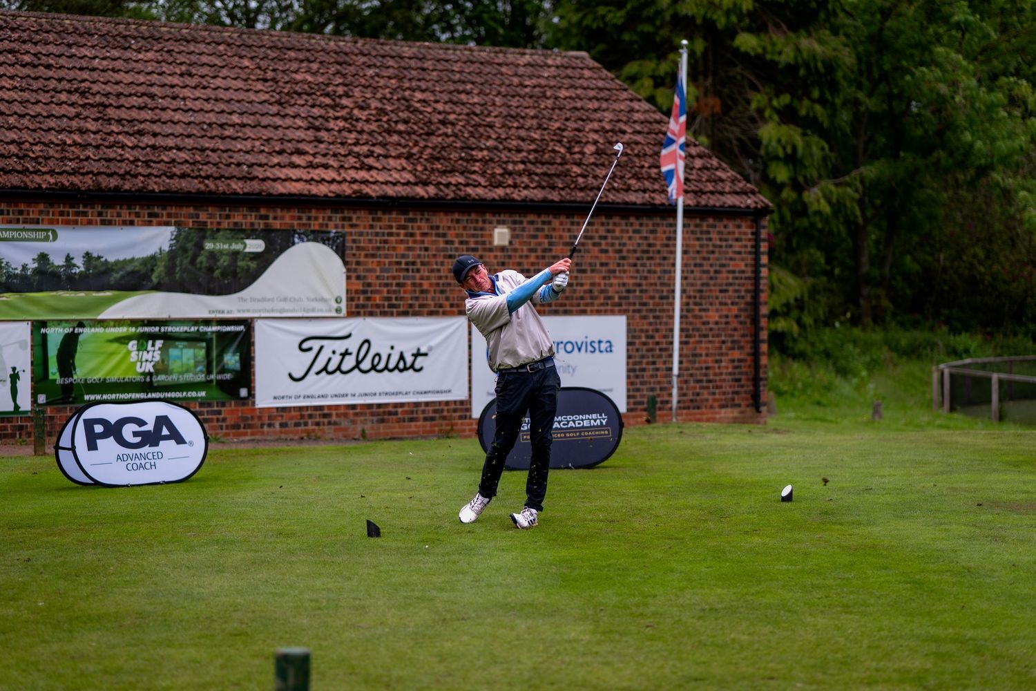 Golfer completes a powerful tee shot at a PGA Titleist sponsored golf tournament event.