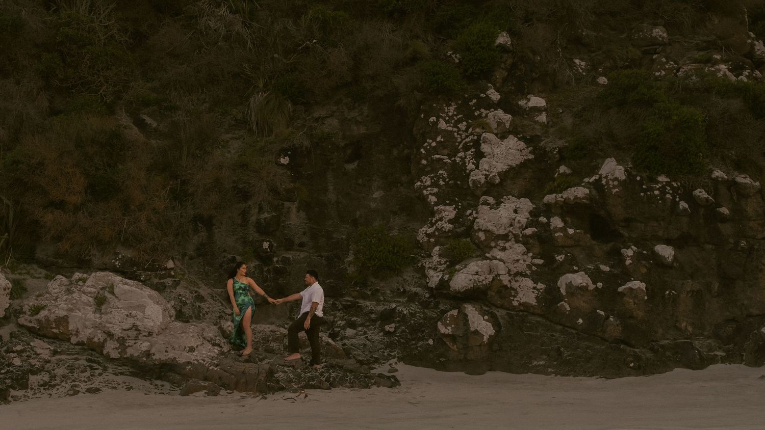 Couple holding hands with rocky backdrop