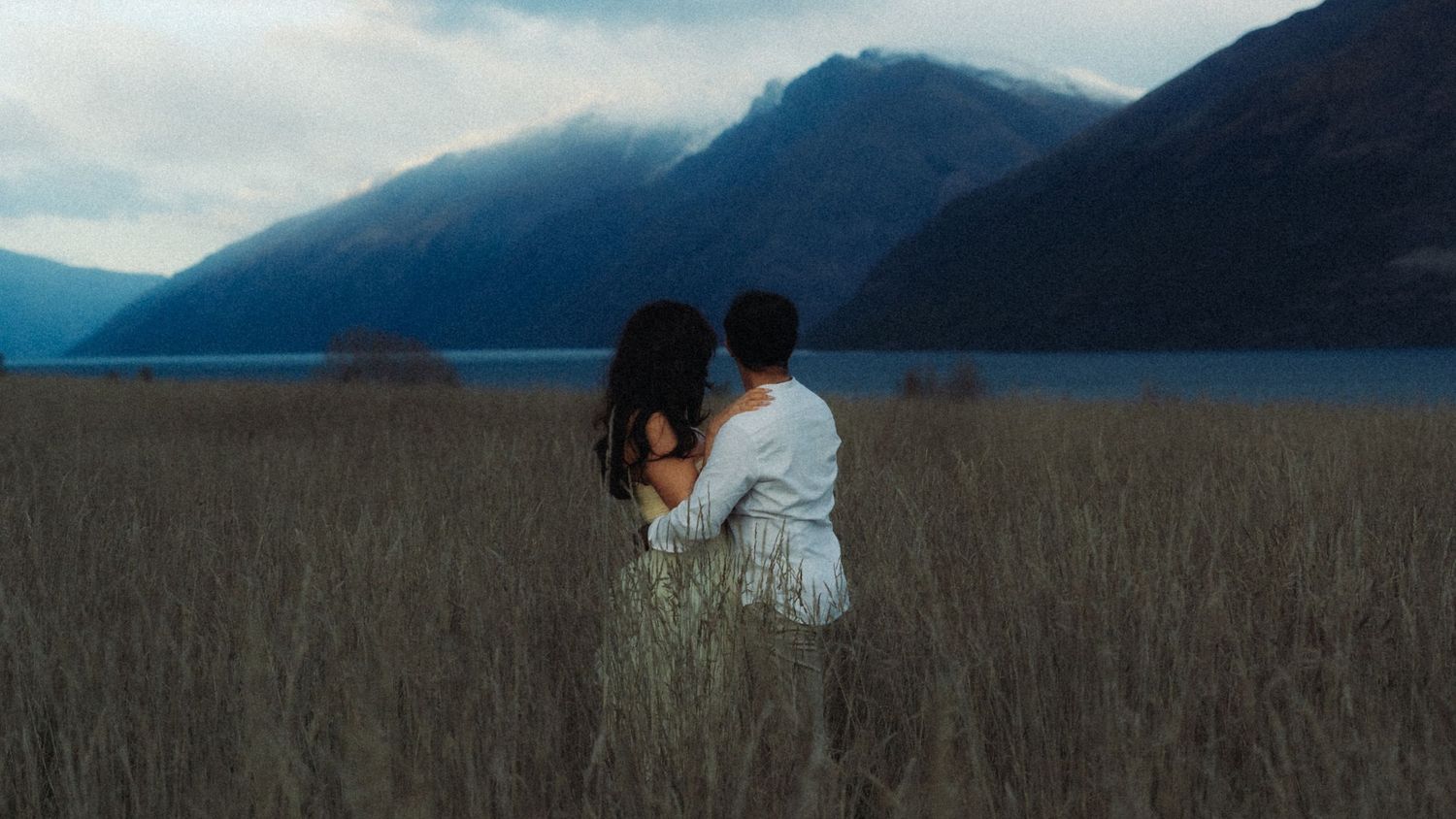 Couple in embrace looking out towards the mountains