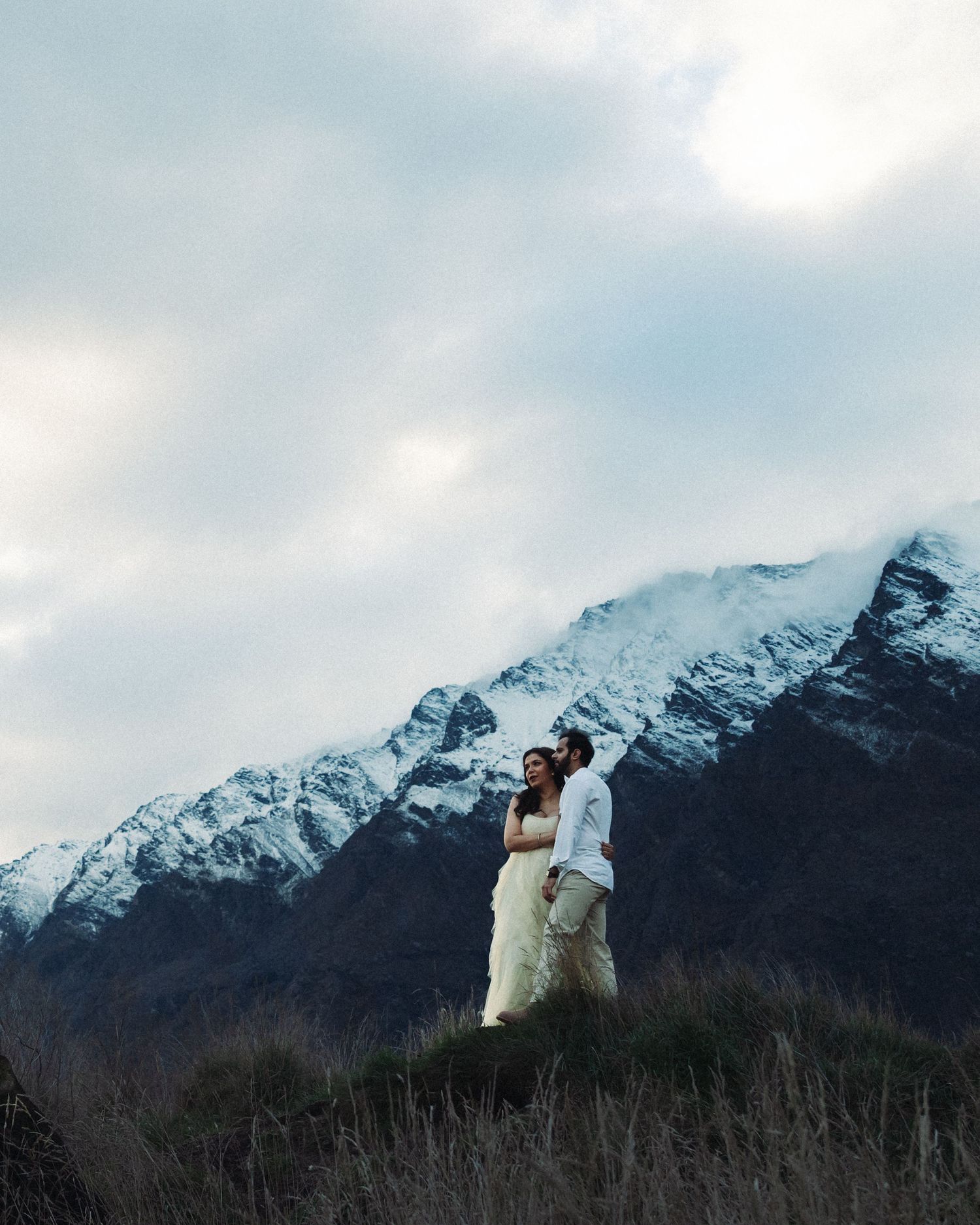 Wedding couple with snow capped mountains behind them