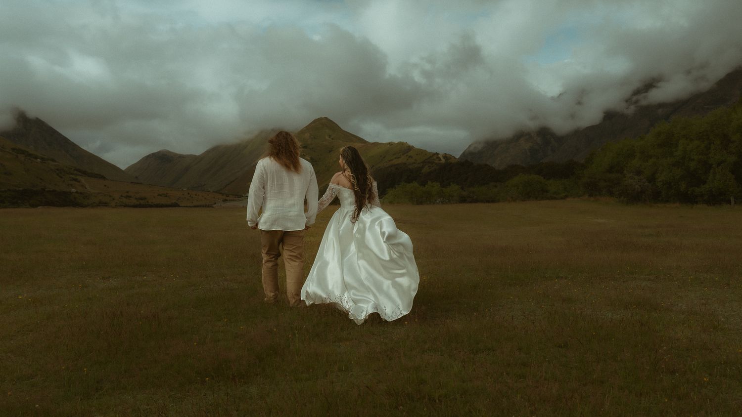 Wedding Couple holding hands. Cinematic image with mountain landscape