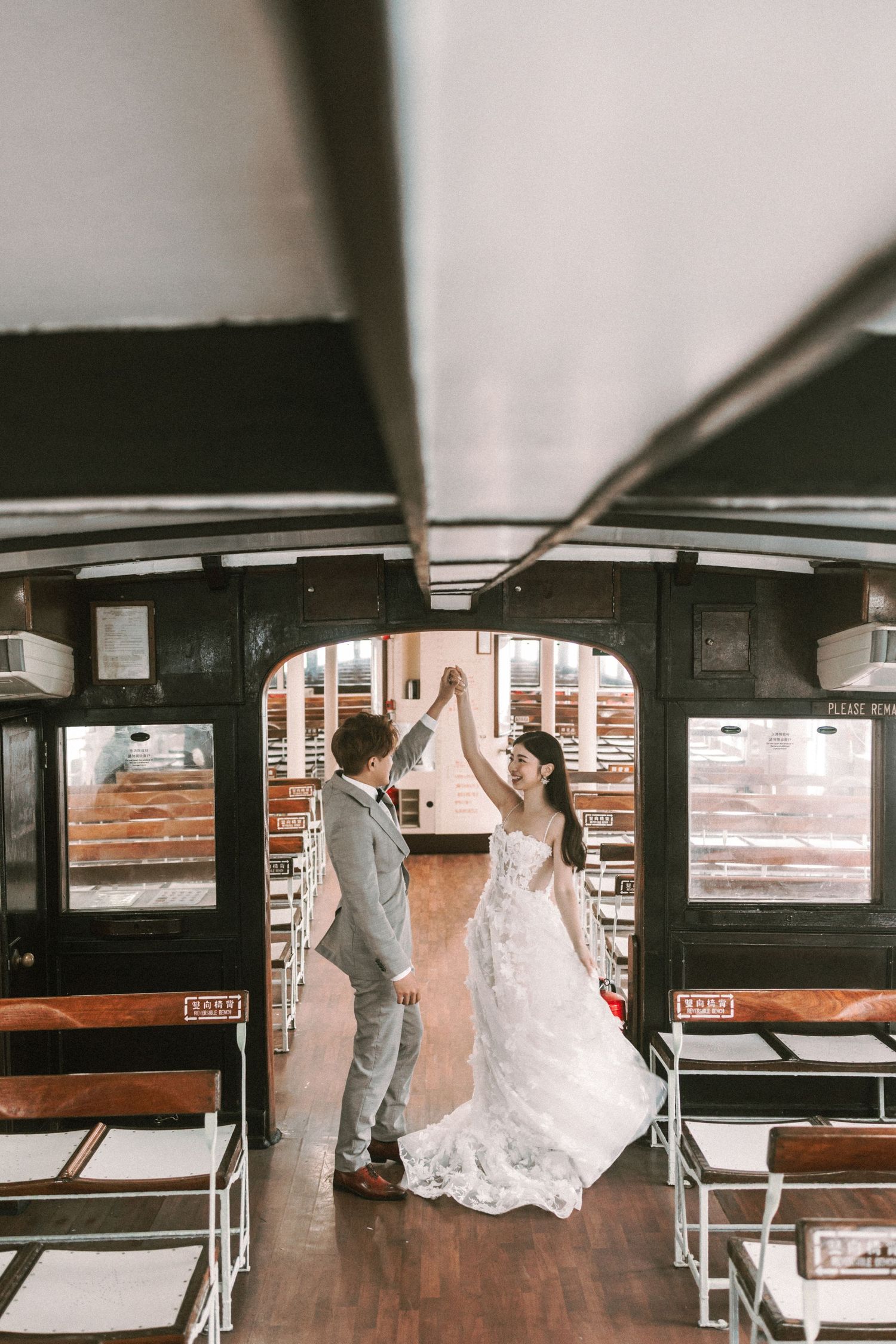 Bride and groom dance together inside a classic wooden ferry boat cabin on their wedding day.