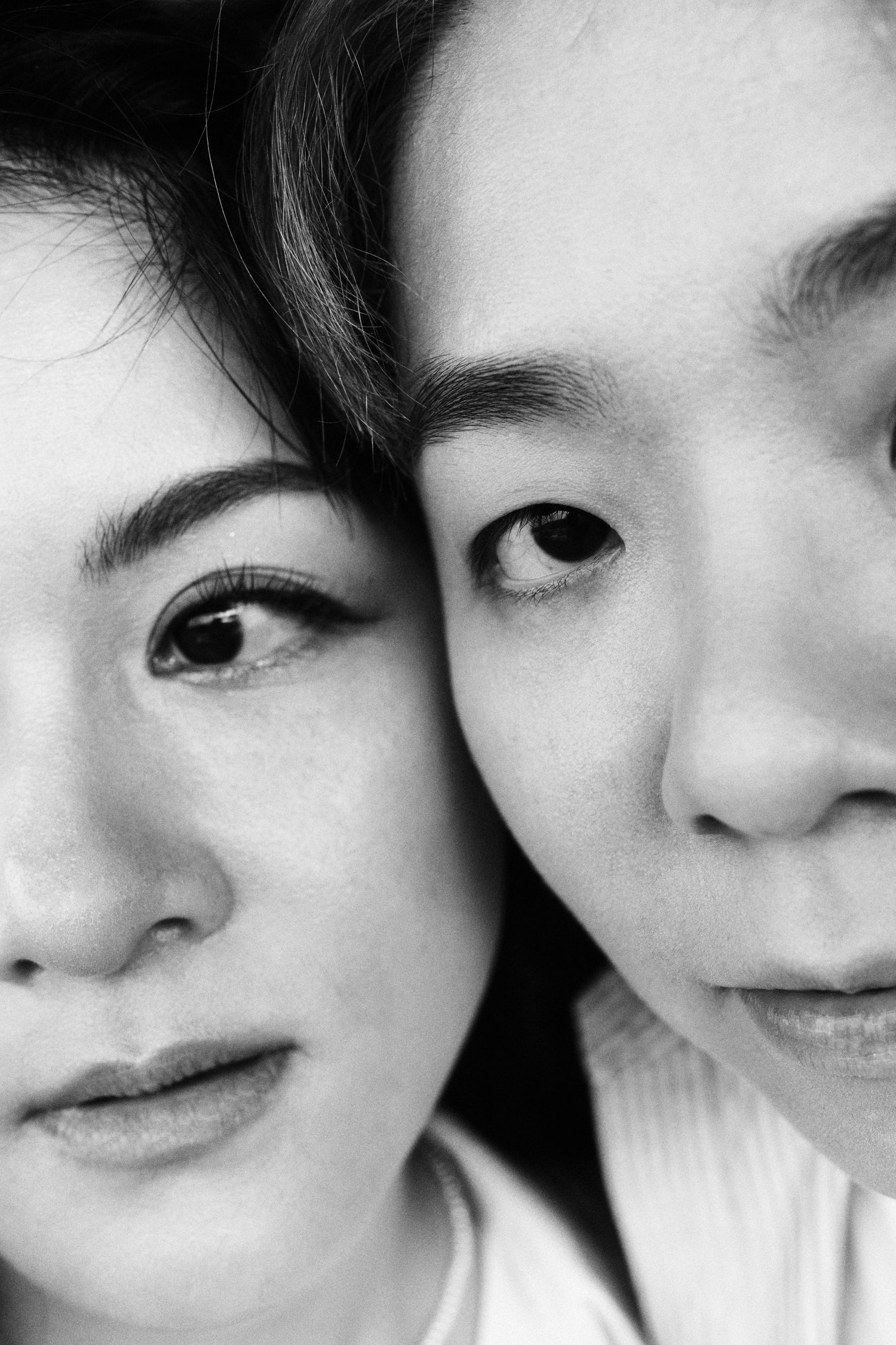 Black and white close-up portrait of two women with faces pressed together intimately.