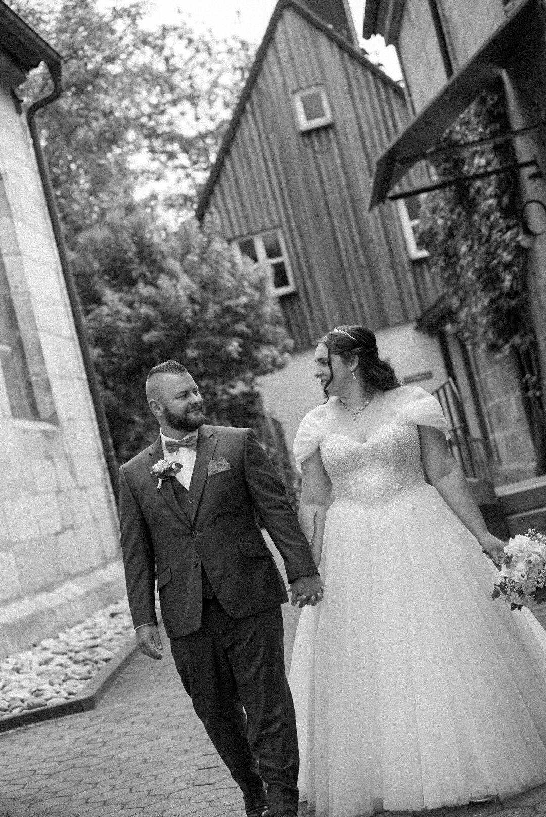 Das Hochzeitspaar läuft in Richtung der Kamera und schaut sich dabei an.