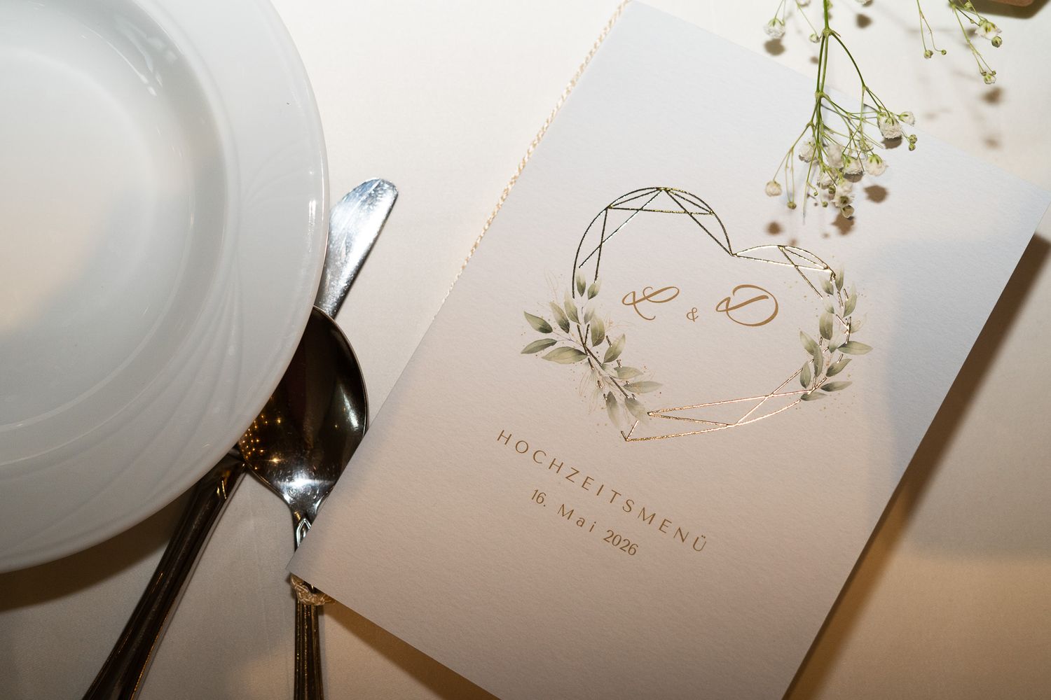 Ein Bild auf der die Hochzeitseinladung und das Essensmenü zu sehen sind.
