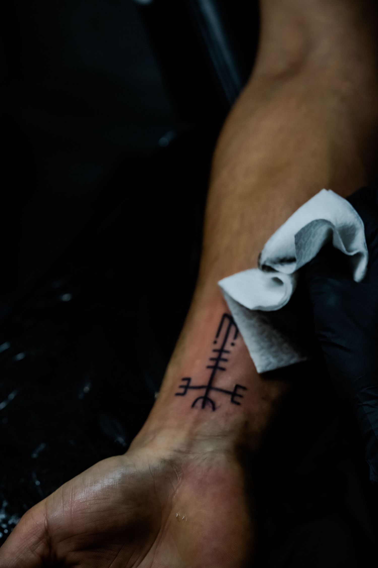 Tatoueuse réalisant un tatouage dans un salon de tatouage à Toulon.