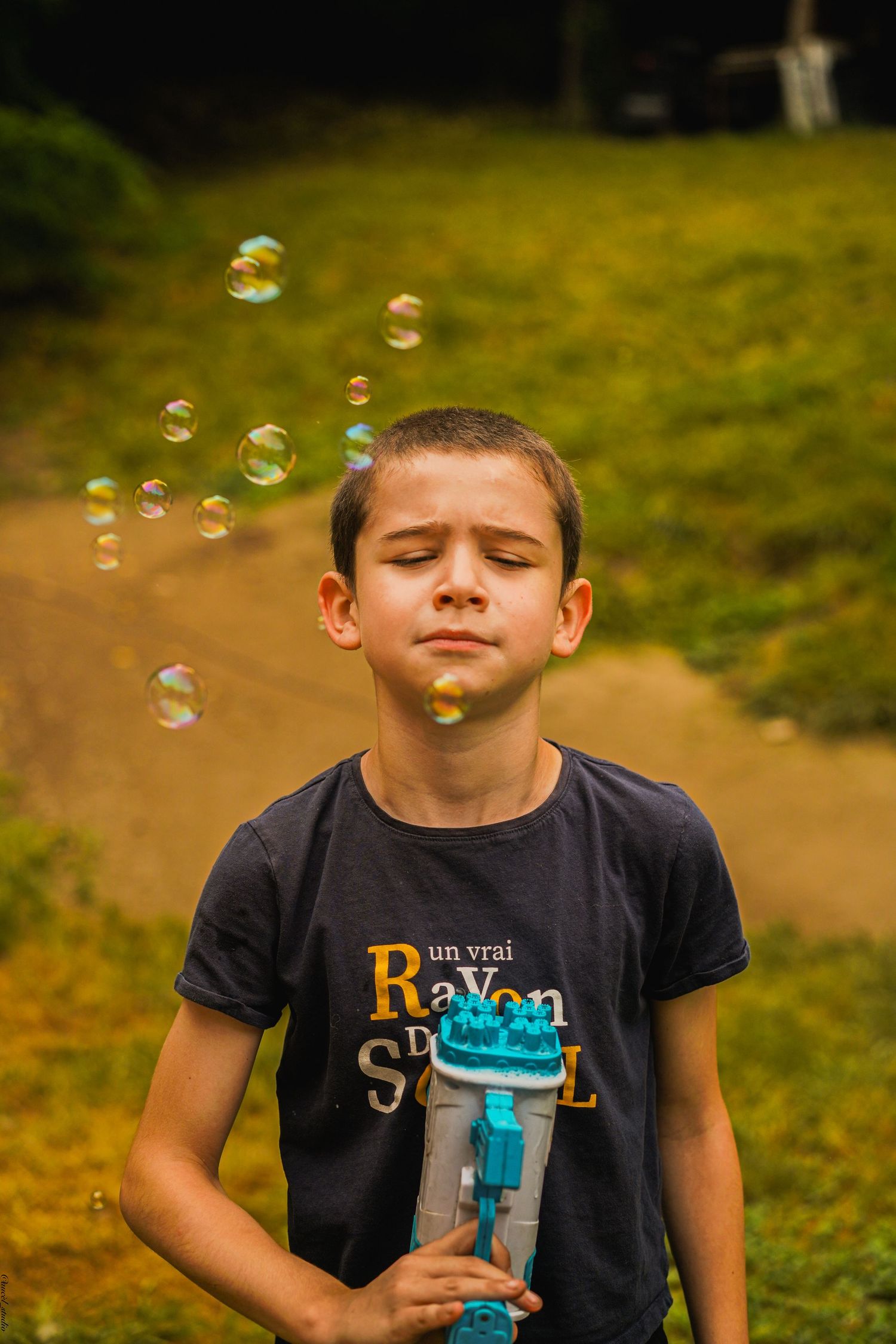 Petit garçon jouant avec un pistolet à bulle lors d'un moment de vie en Ariège.