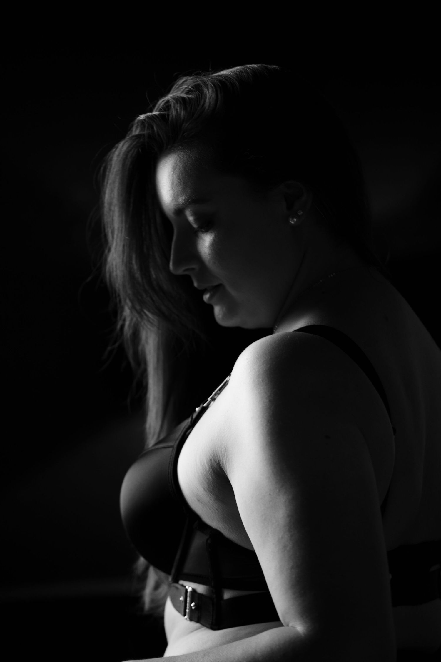 Portrait de femme en noir et blanc lors d'une séance photo boudoir à la lumière naturelle.