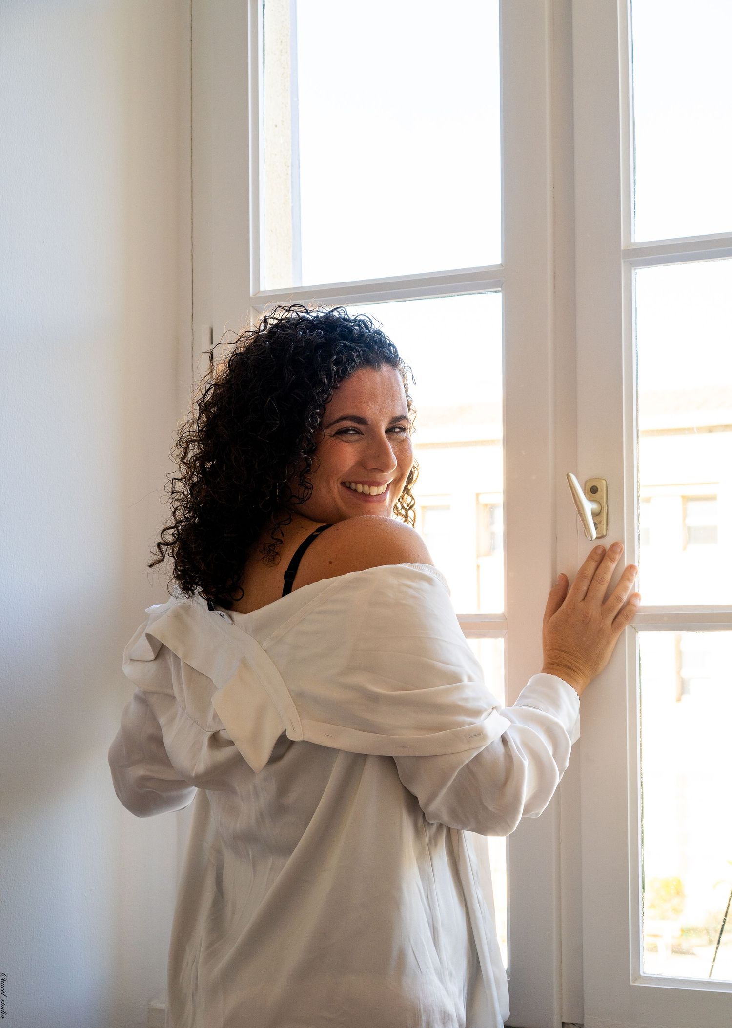 Portrait boudoir d'une femme debout devant une grande fenêtre à Toulon.