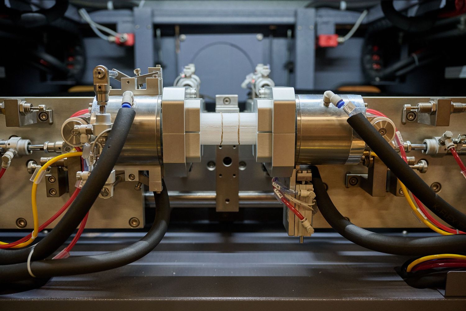 Close-up of precision industrial hydraulic machinery with metal fittings and colorful wiring.