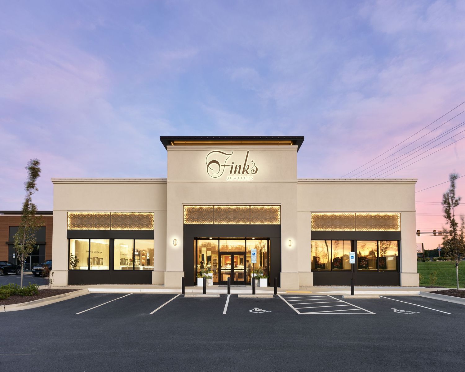 Elegant Finks jewelry store exterior at sunset with large windows and illuminated storefront signage.