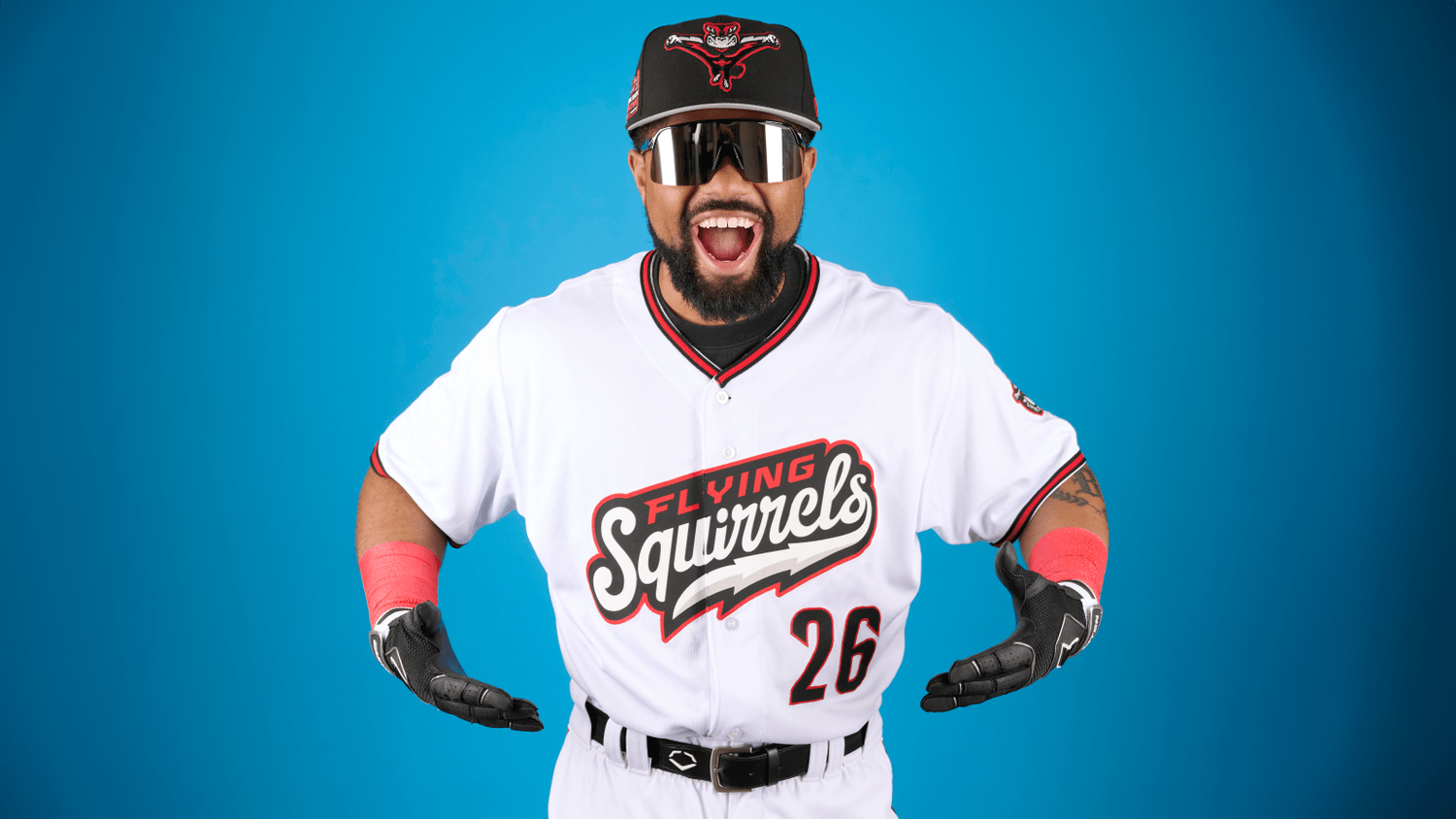 Richmond Flying Squirrels baseball player number 26 posing in white uniform against a blue background.
