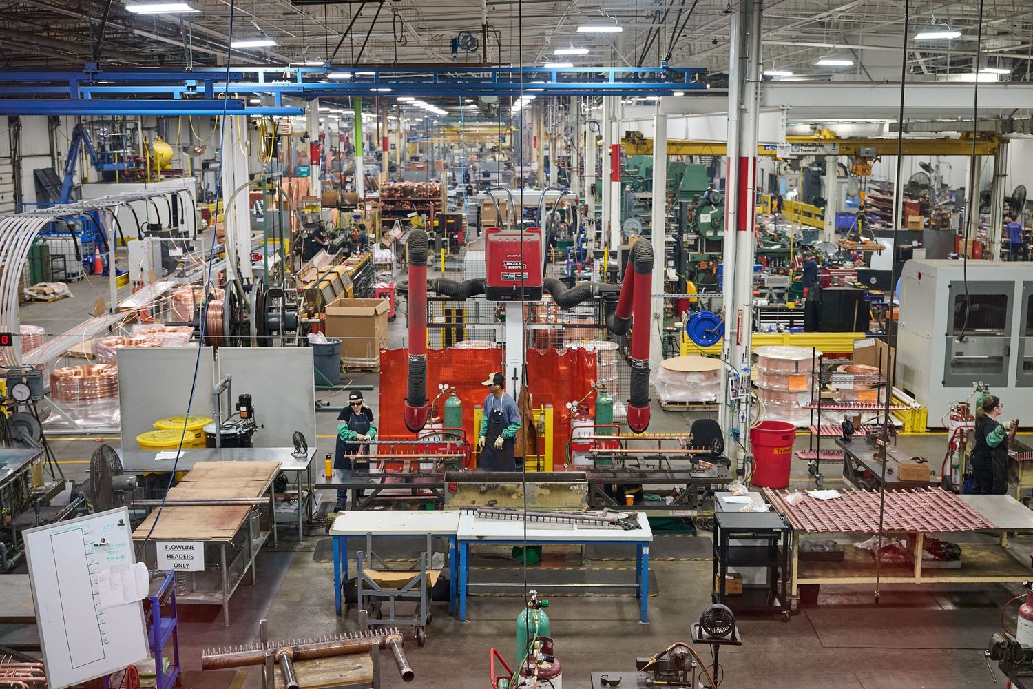 Aerial view of a busy industrial manufacturing factory floor with workers and machinery.
