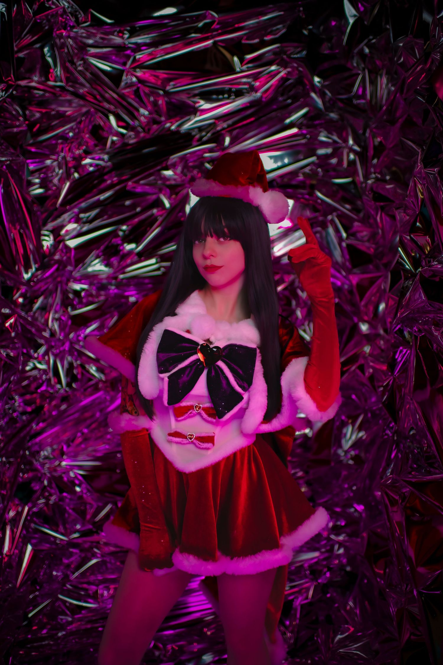 Woman in festive red costume strikes dramatic poses against sparkling purple tinsel backdrop.